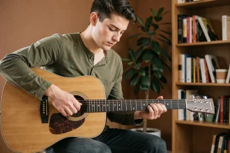 Jeune guitariste apprenant les accords de guitare acoustique dans un salon chaleureux